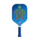 The 4Joy Paddles blue pickleball paddle features a honeycomb core and a vibrant turtle design in green, red, and yellow. Its handle is finished with blue grip tape for added comfort and style.